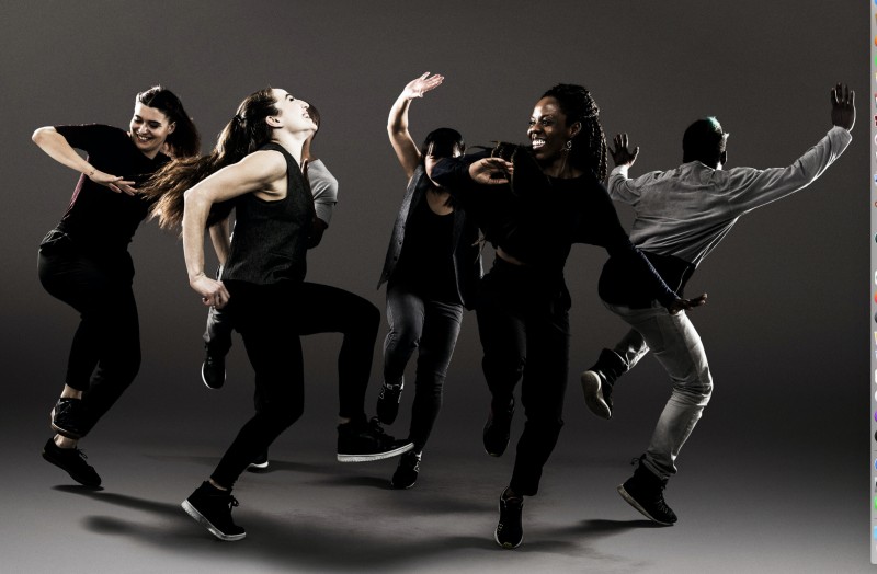 Israeli B-girl Ephrat Asherie in the middle of a dance move with her joyous social dance company of all colors wearing black and white